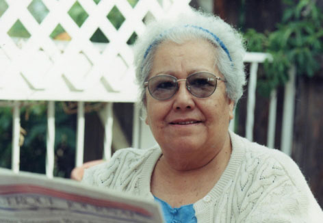 an older woman reads the newspaper